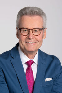 Ulrich Wendt mit blauem Jackett und pinkfarbener Krawatte.